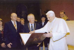 Landrat Hermann Steinmaßl (links) und Oberbürgermeister Fritz Stahl überreichen an der Spitze einer städtischen Delegation am 8. Februar 2005 in Rom die Ehrenbürgerurkunde. © Stadtarchiv Traunstein