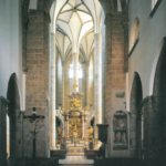 Das dunkle romanische Langhaus der Franziskanerkirche kontrastiert mit dem lichtdurchfluteten spätgotischen Hallenchor © C. Schneeweiss